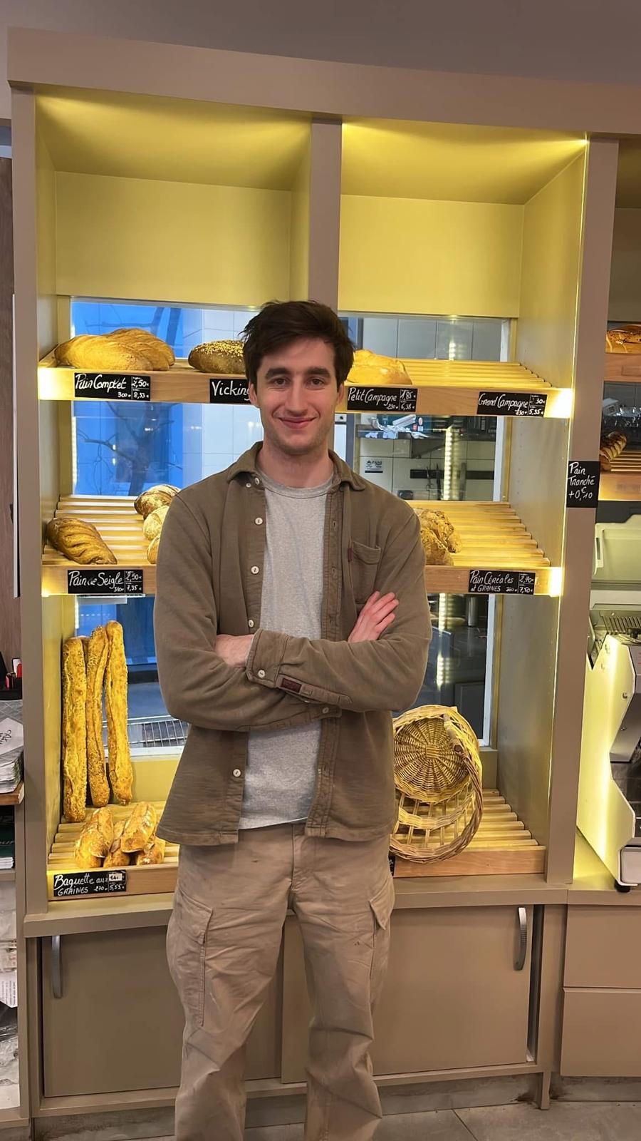 Virgile, artisan boulanger au Boulanger du Coin à Vélizy-Villacoublay, devant ses rayons de pains